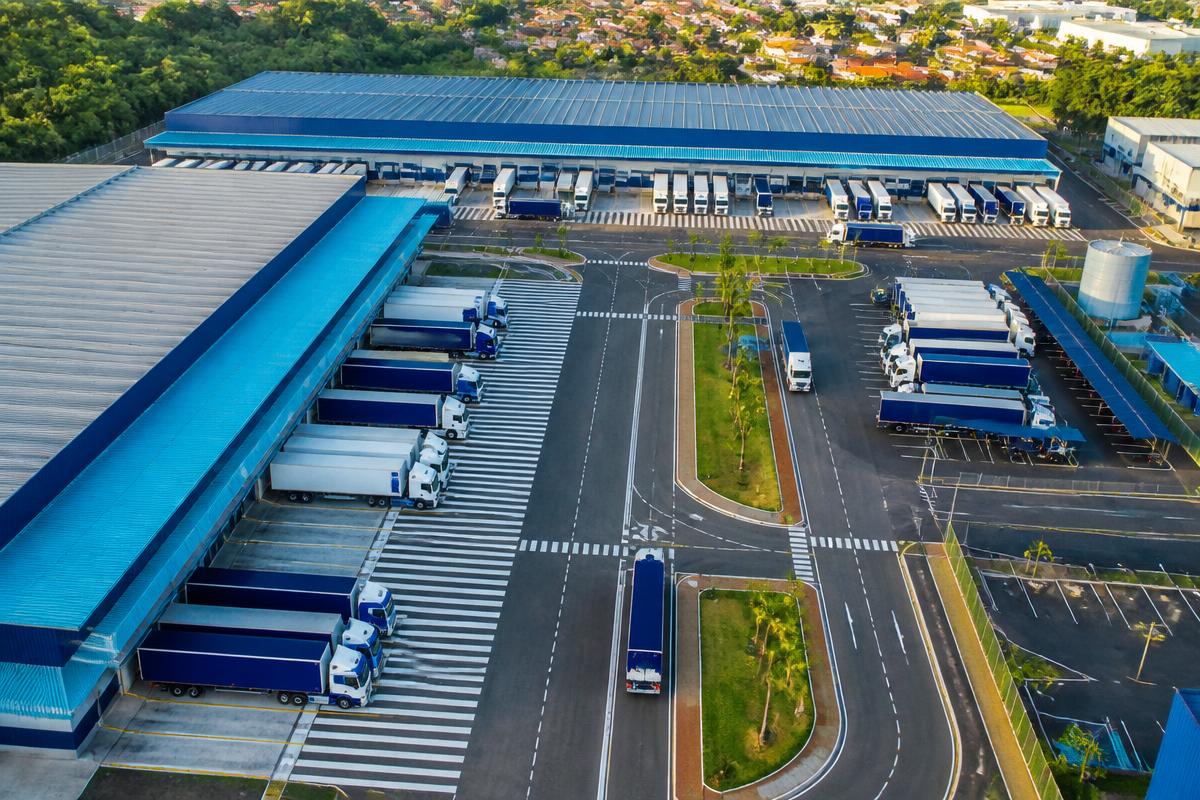 Vista aérea de um centro de distribuição com caminhões e docas organizadas